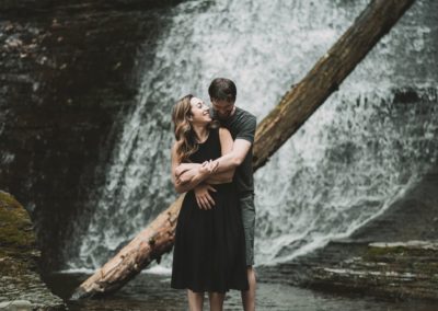 couple engagement session at a waterfall at watkins glen, new york
