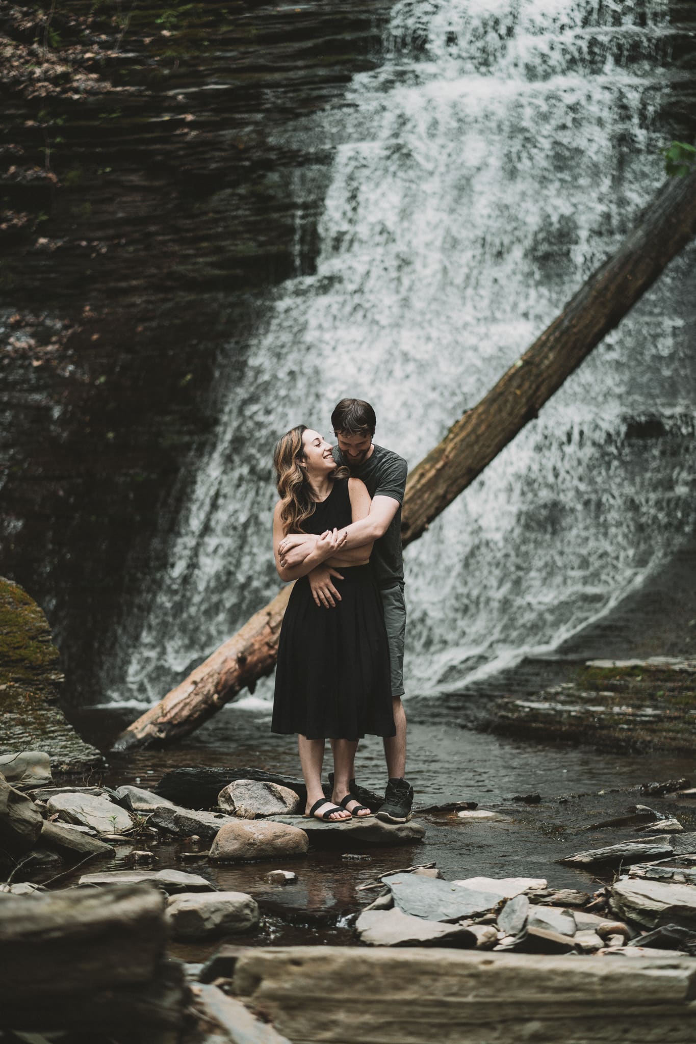 couple engagement session at a waterfall at watkins glen, new york