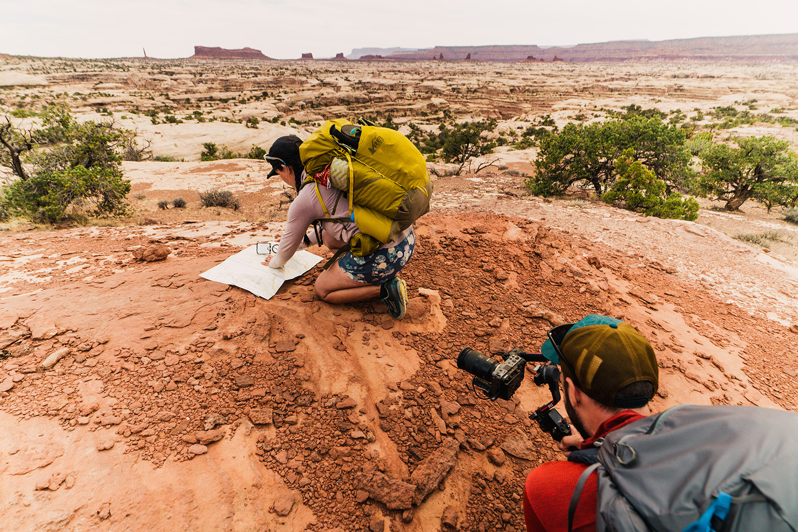 woman and videographer pose with her map of the maze in utah canyonlands national park