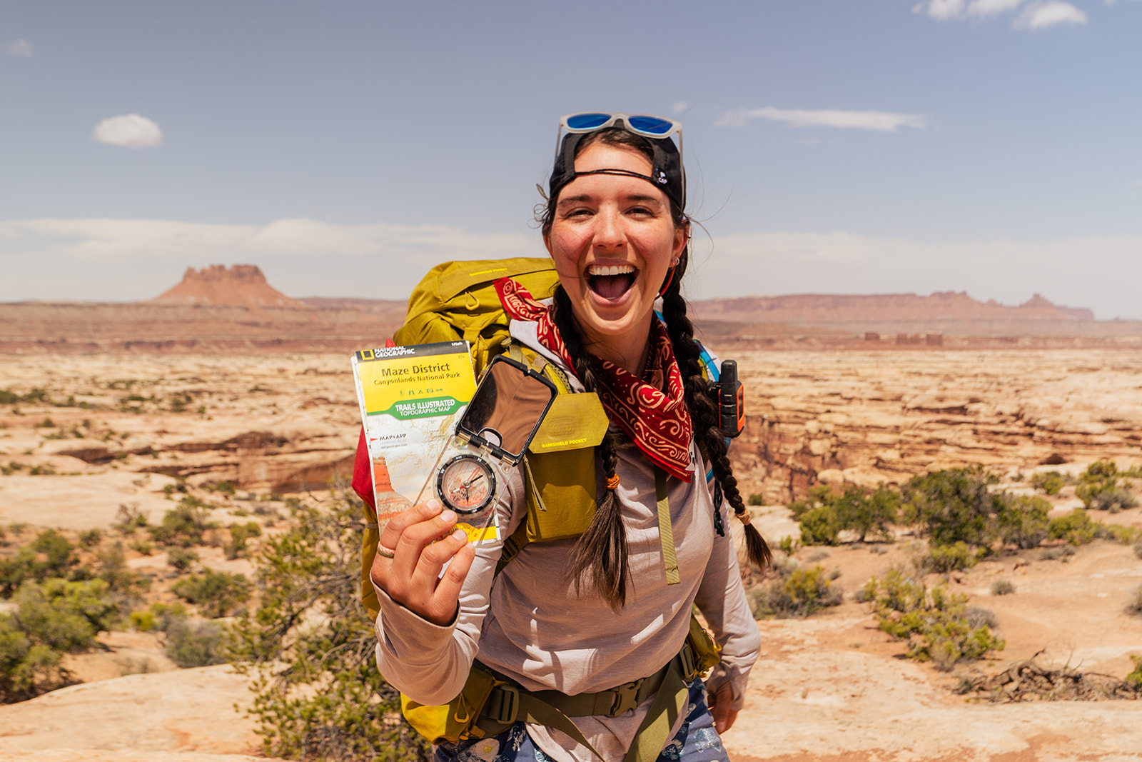 woman poses with her map of the maze in utah canyonlands national park